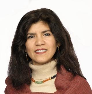 Manuela Orjuela Manuela is wearing a beige turtleneck and a red scarf.